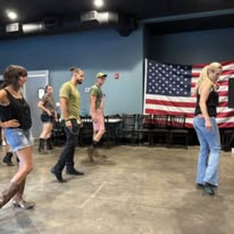 Line dancers with American flag at The Airport Inn